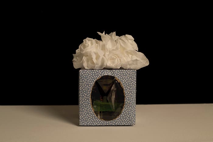 A box with an oval window and roses on top.