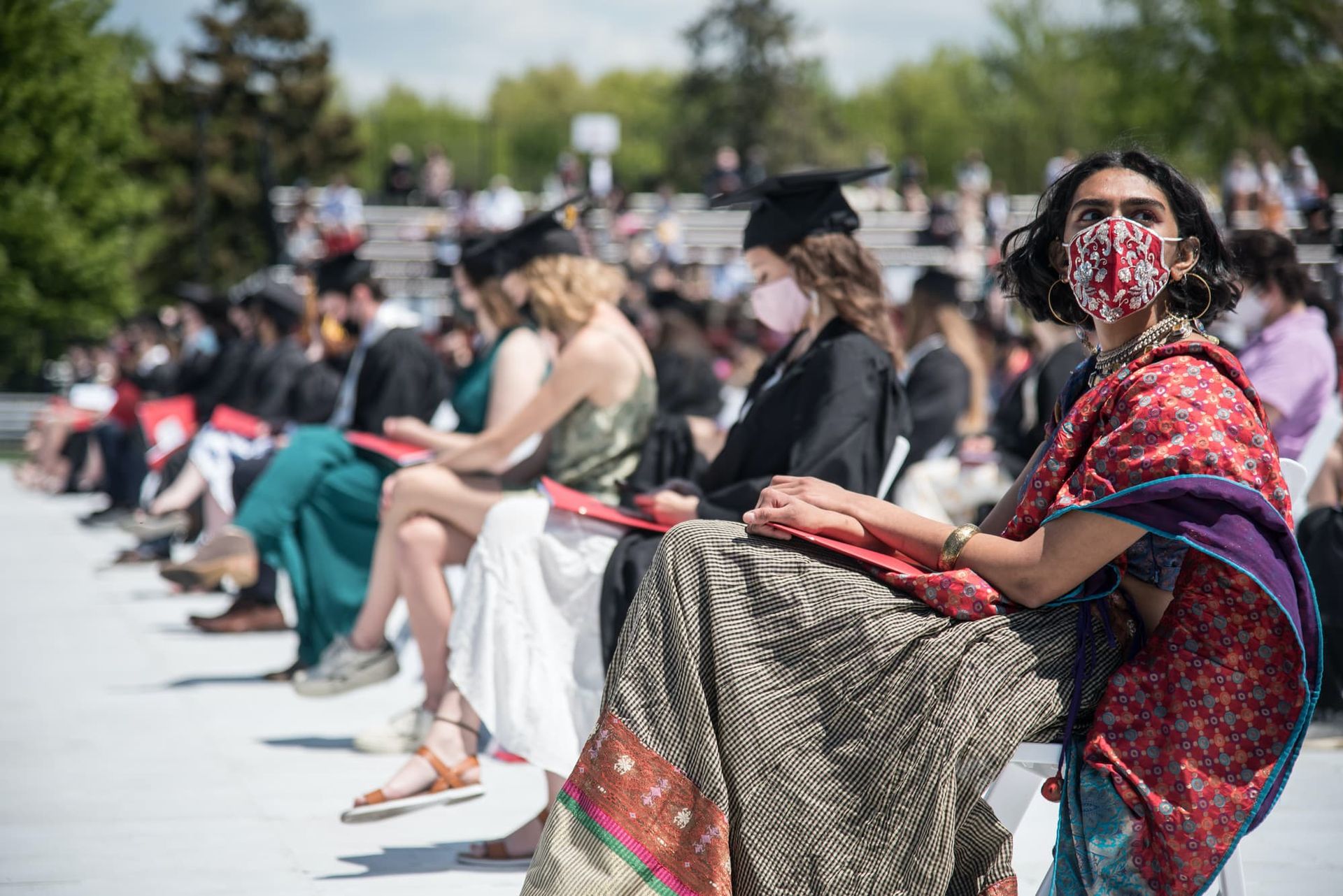 A woman and college student bump elbows.