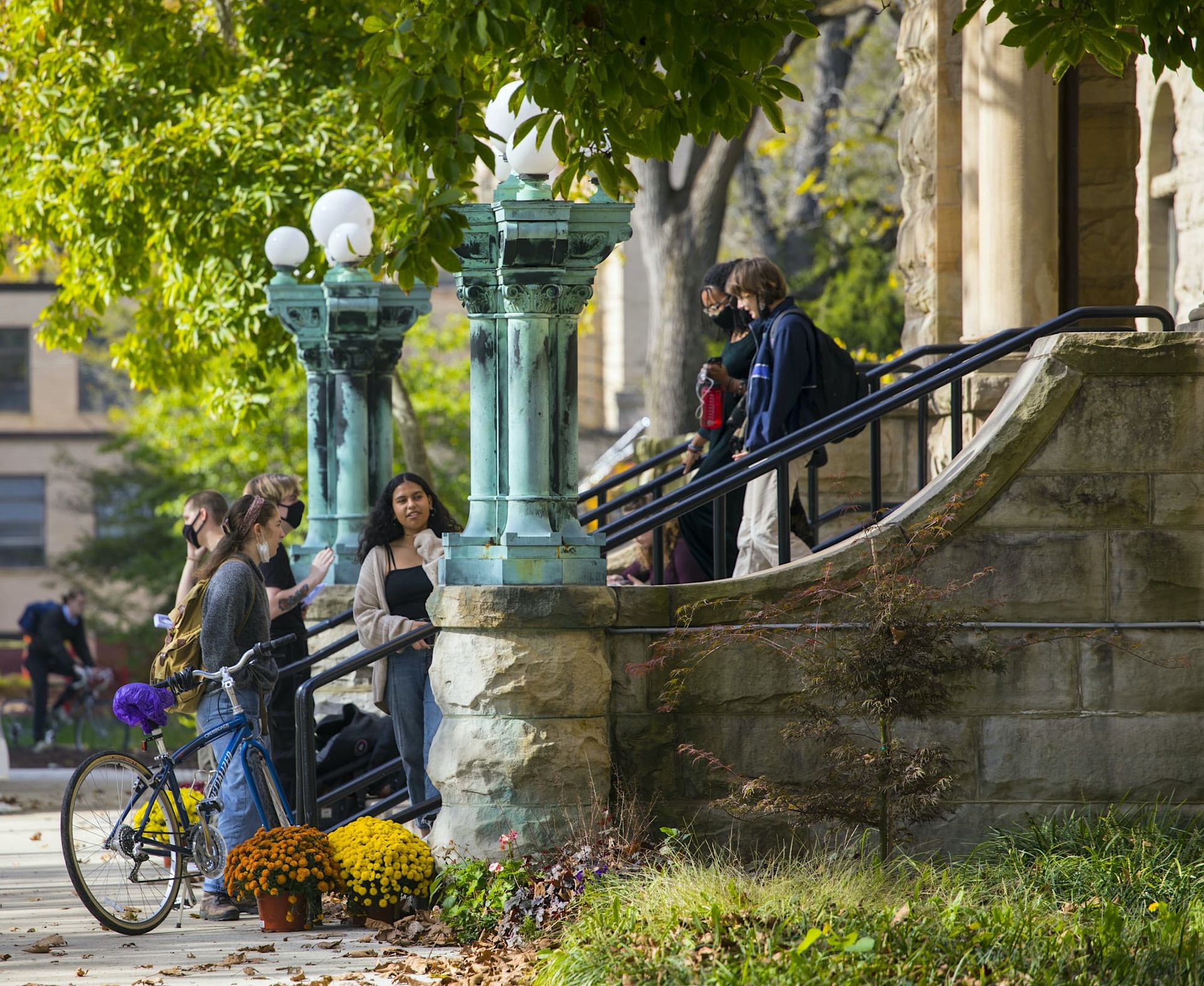 Students congregate at the bottom of an outside stone staircase.