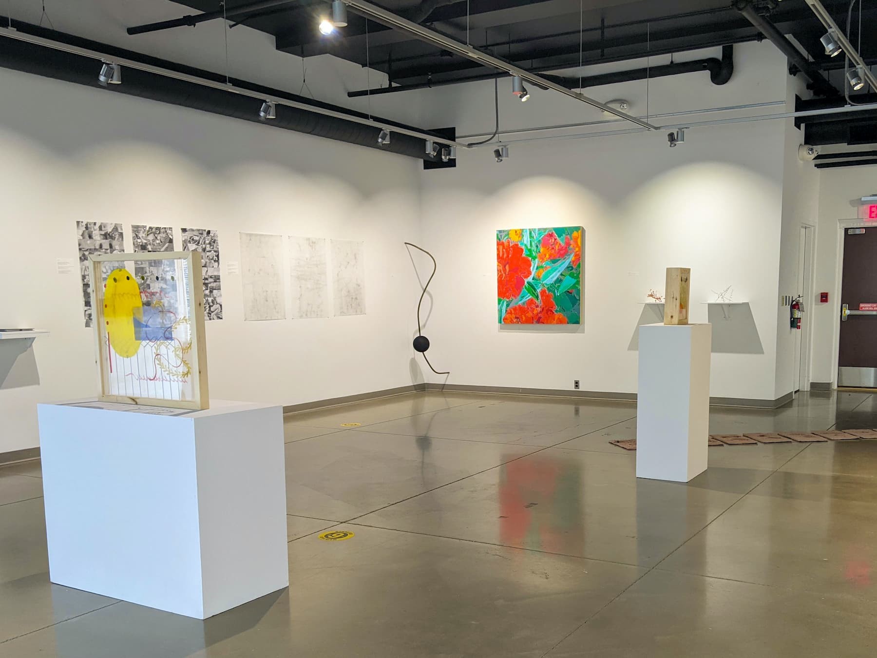 An art exhibition with sculptures, paintings, and drawings.