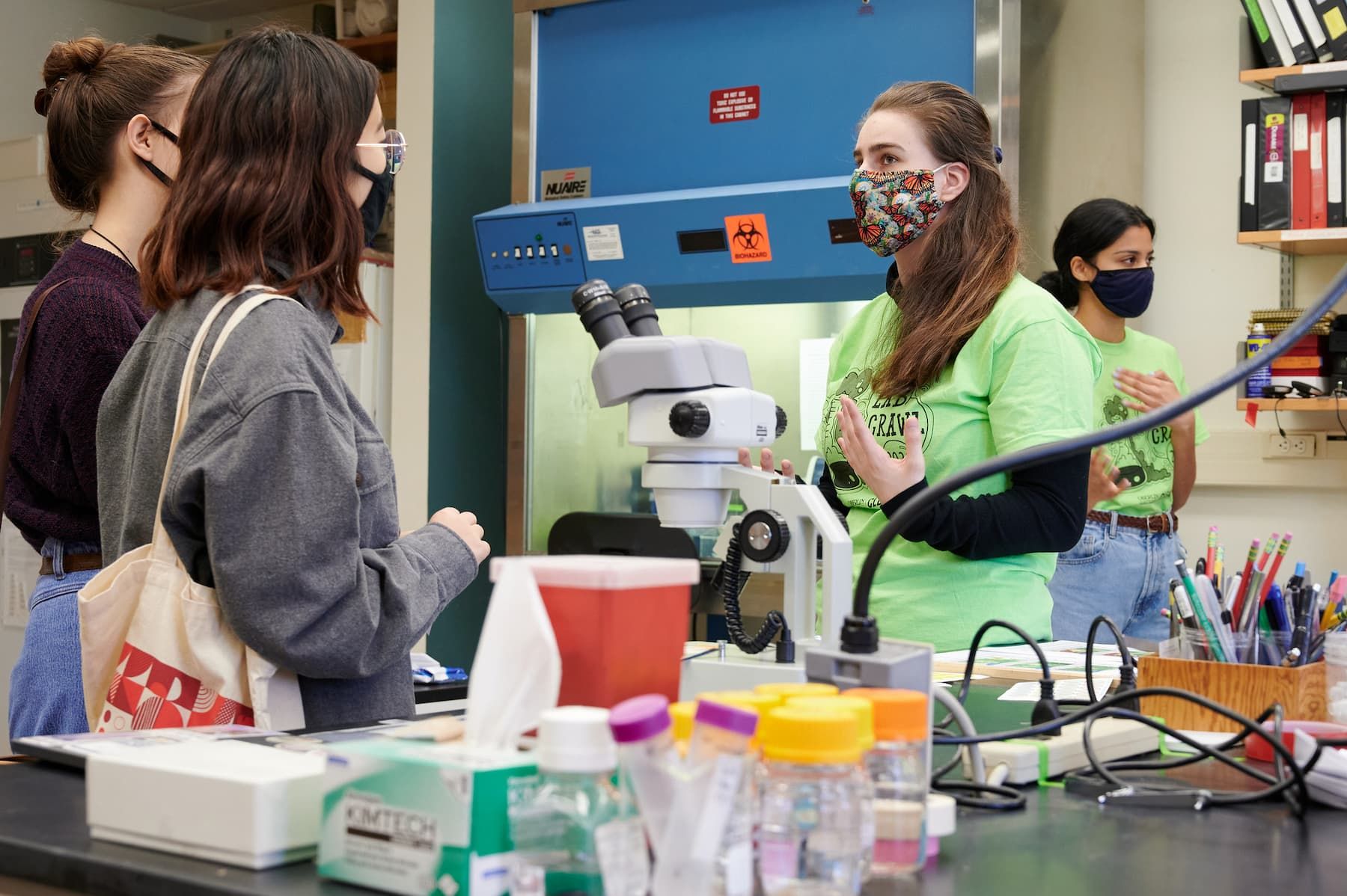 Student visitors too a science lab speak with a peer guide.
