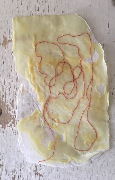 Wax on a sheet of paper with a string stuck in it.