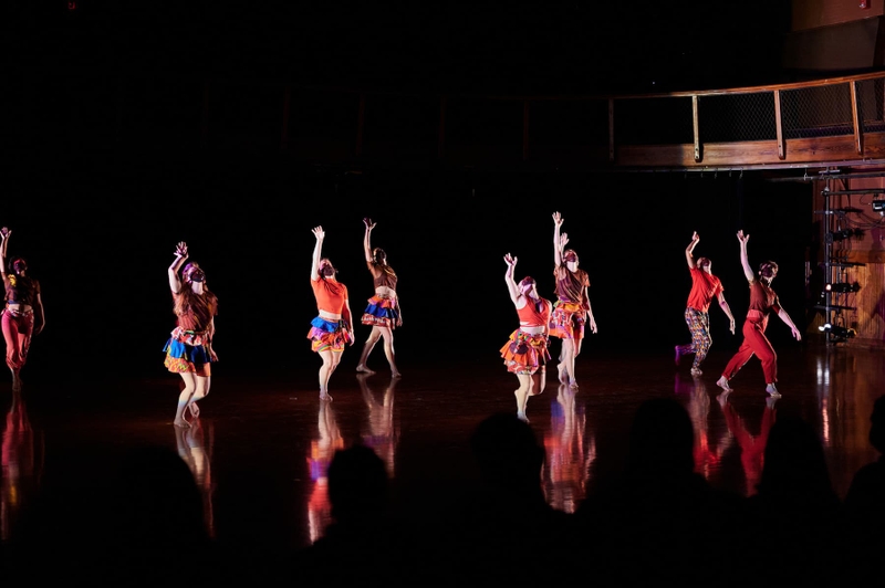 A group of dance students point their toes during a performance.
