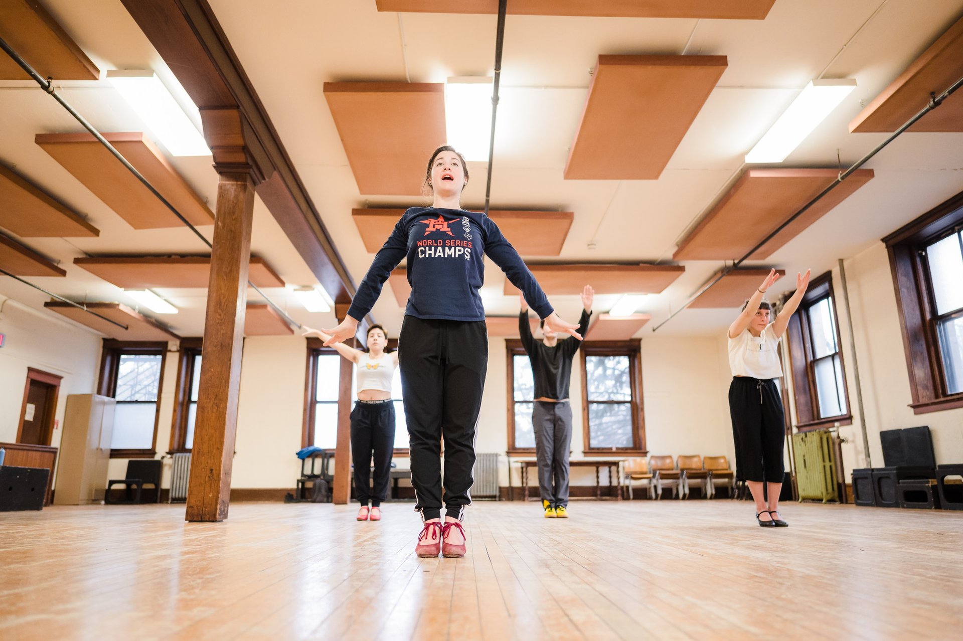 A person leads a small group of students in a flamenco dance class.