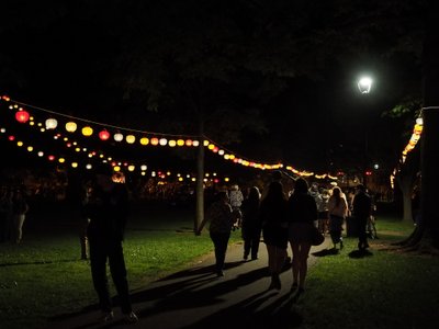 People walking under lanterns in the dark