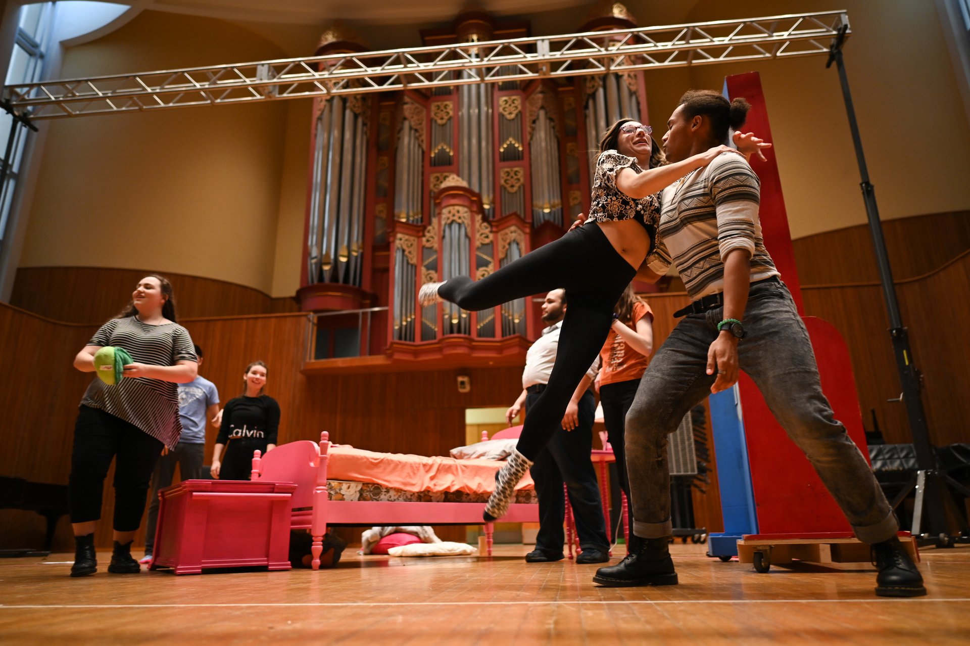 A girl jumps in a man's arms on stage.