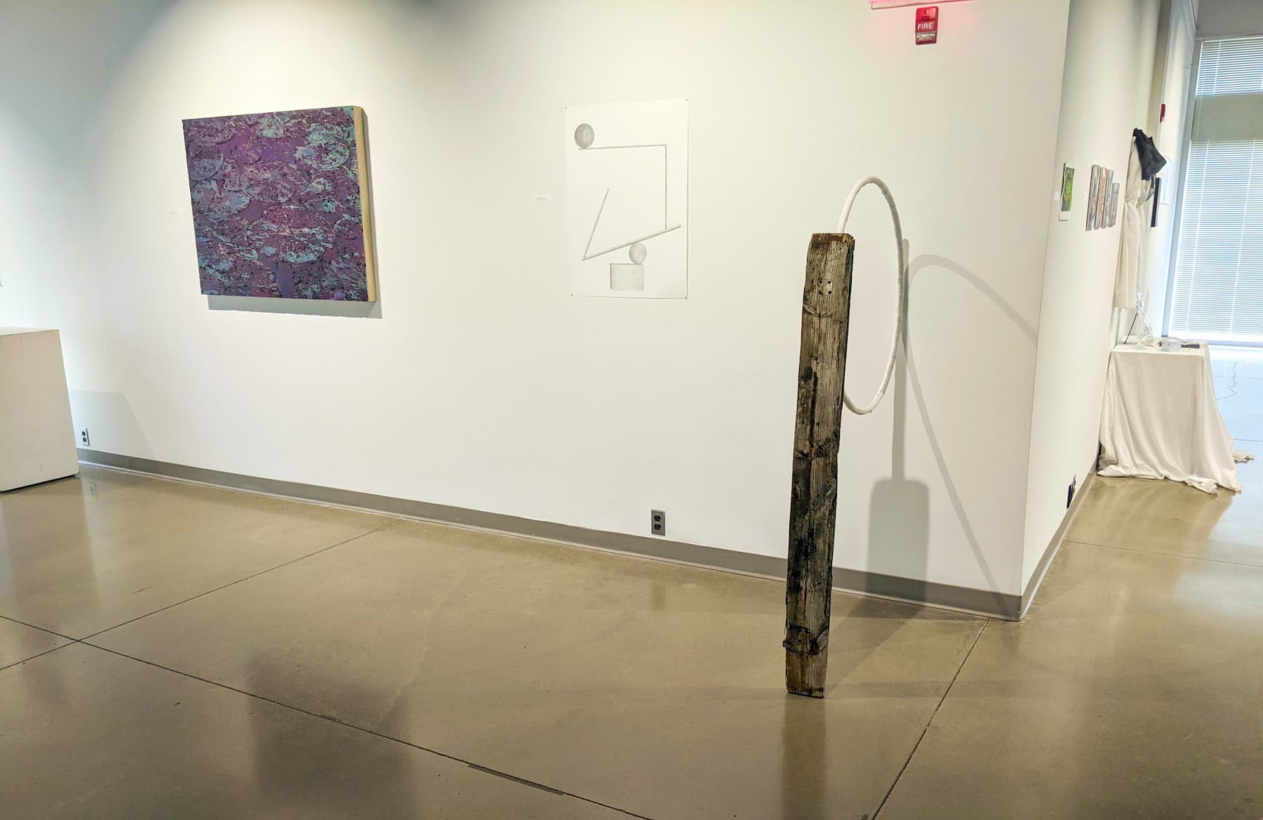 An art exhibition with sculptures, paintings, and drawings.