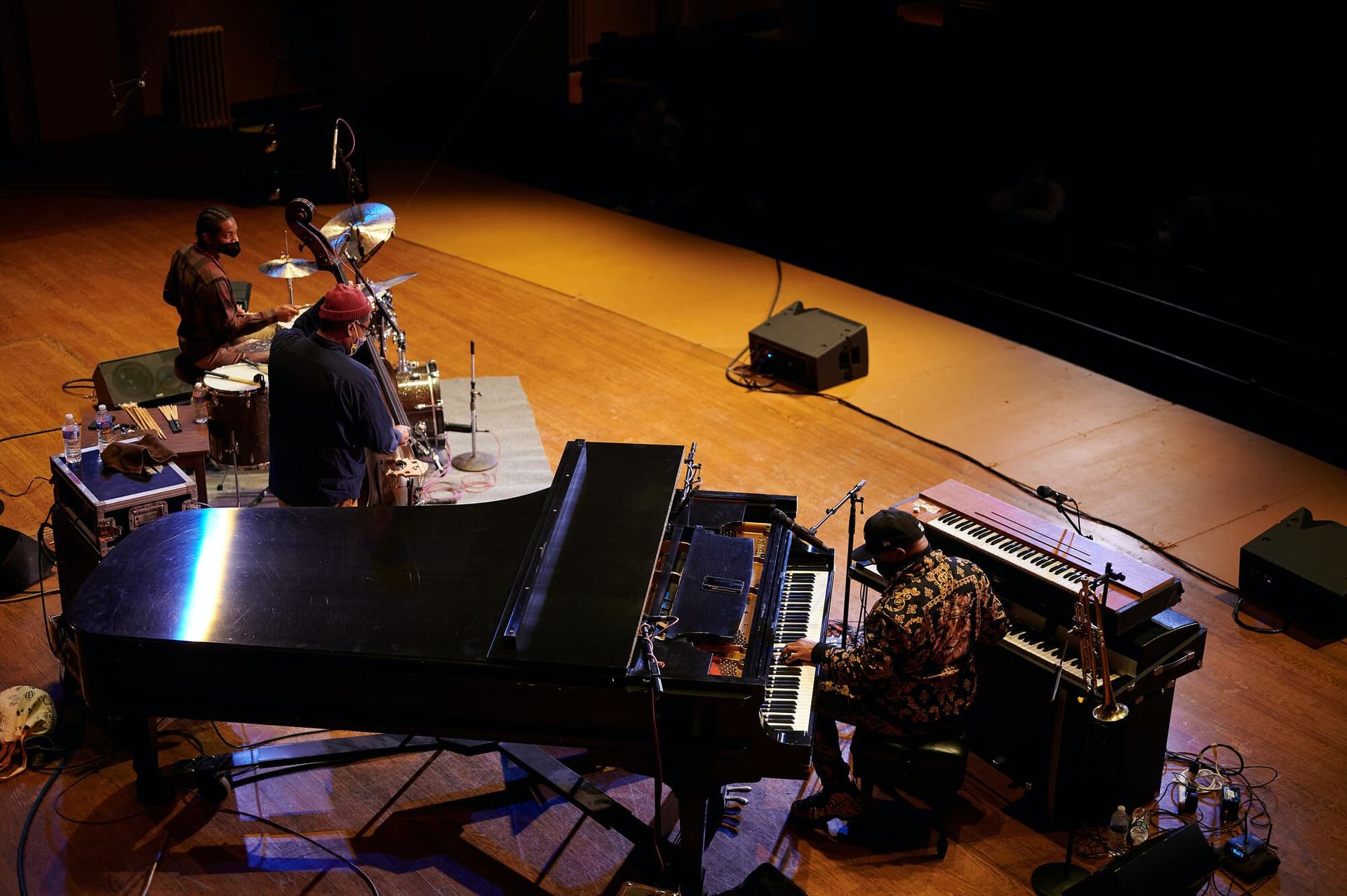 A trio gives a performance on a large stage.
