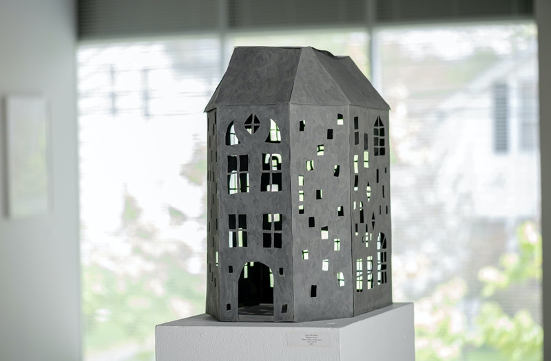 A small sculpture of a house with lots of windows.