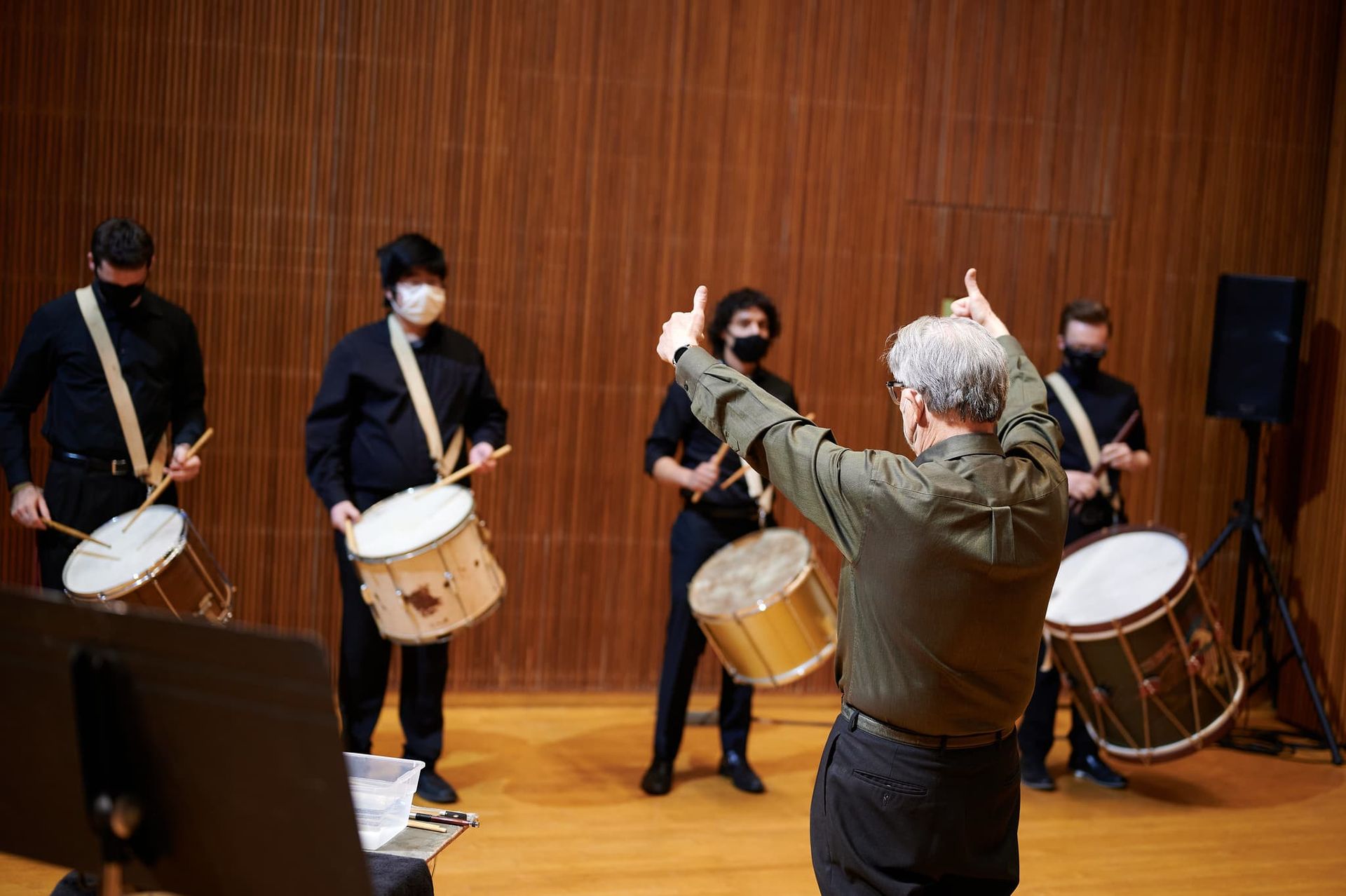 Drummers get a thumbs up from their conductor.