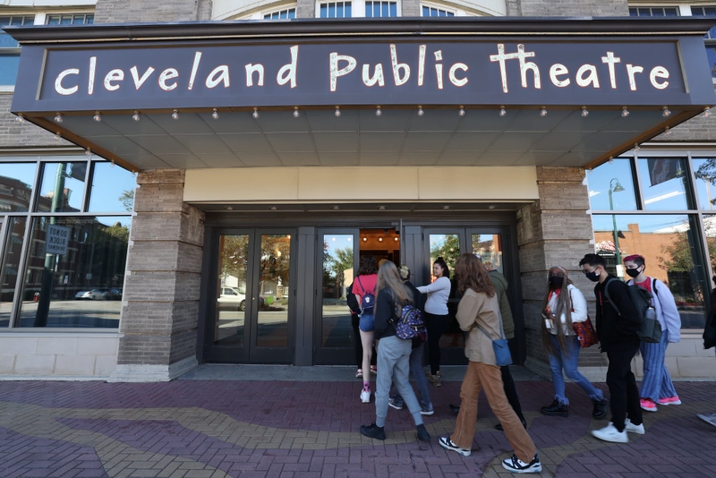 Students enter a theater building.