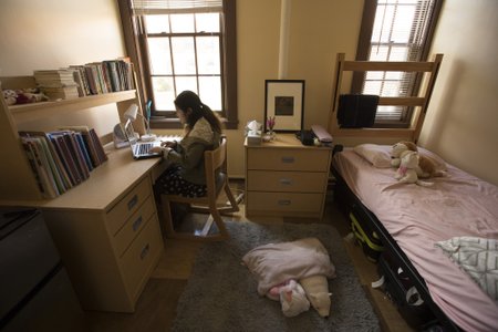 A student works at a desk in her room.