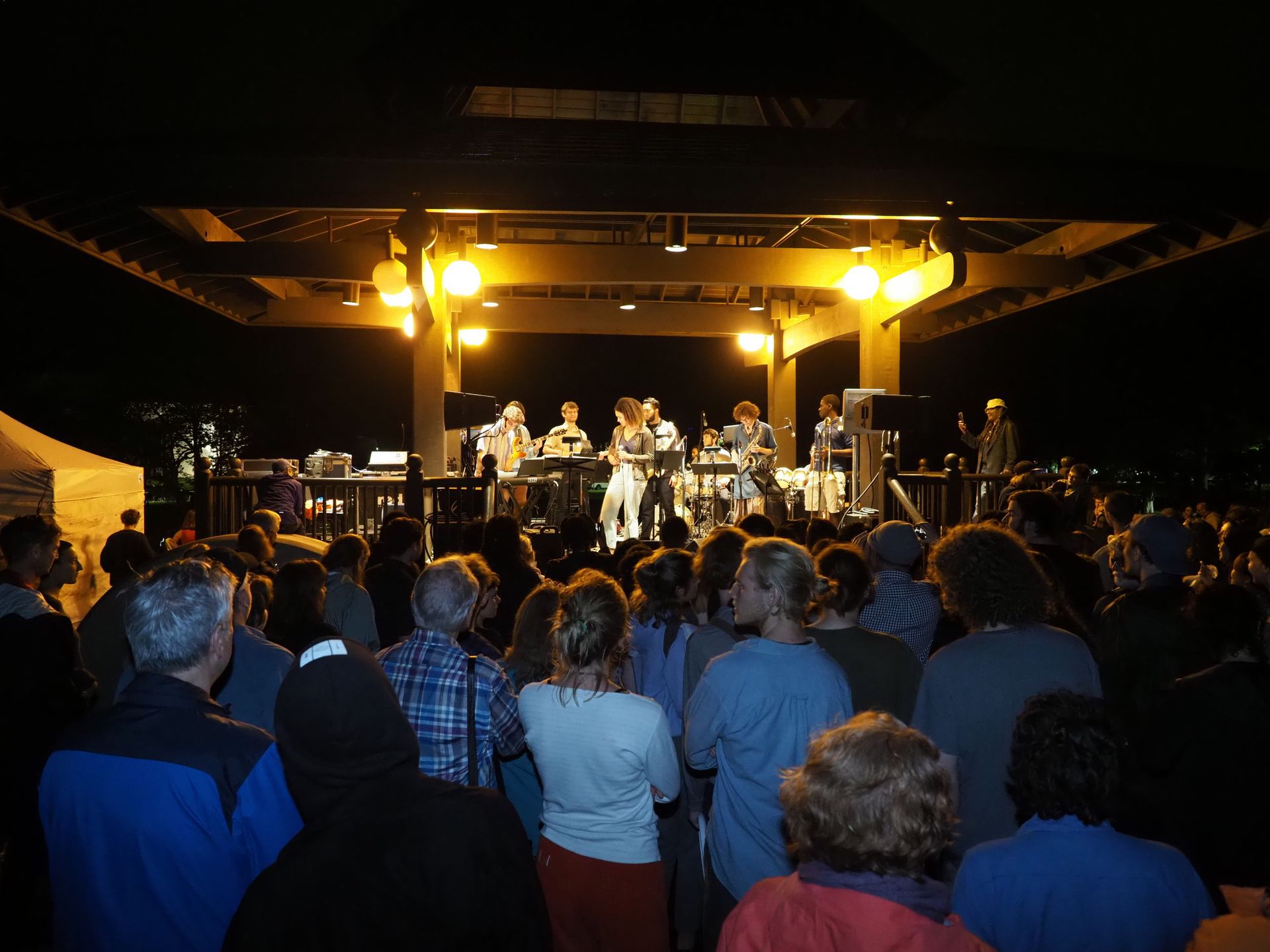 People crowded around a band in a gazebo