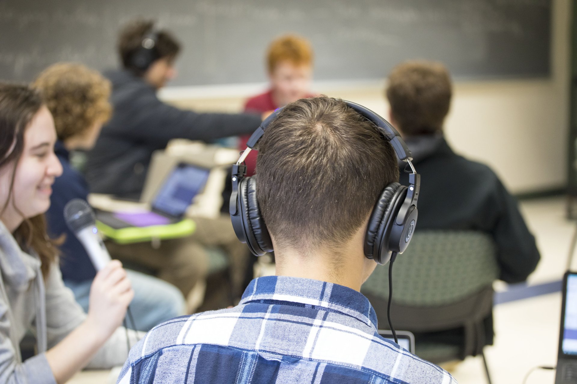A male student adjusts a large microphone.
