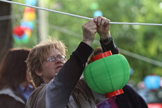 A woman hangs a lantern on a rope
