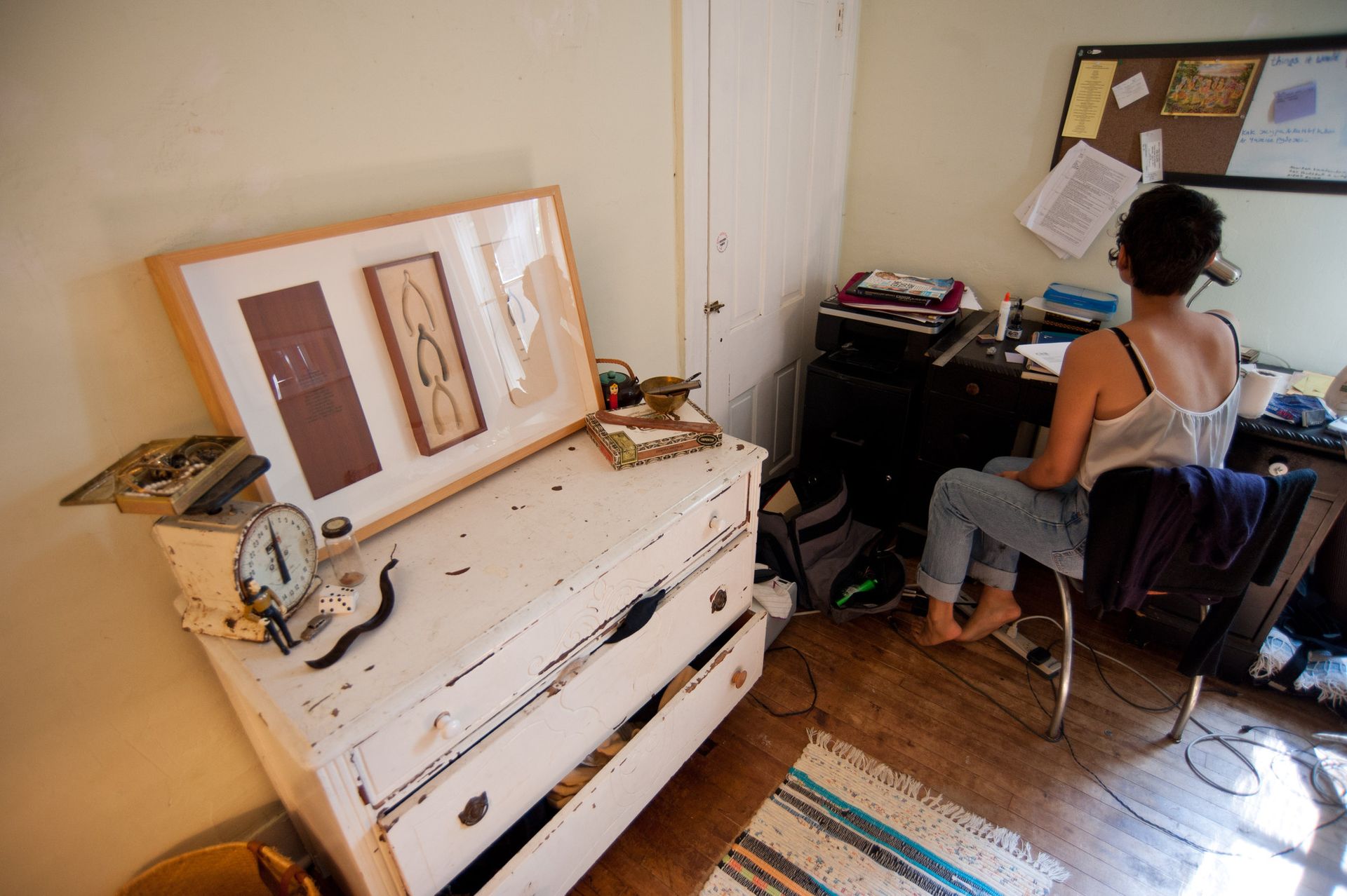 Large artwork with framed wishbones sits on a rustic dresser.
