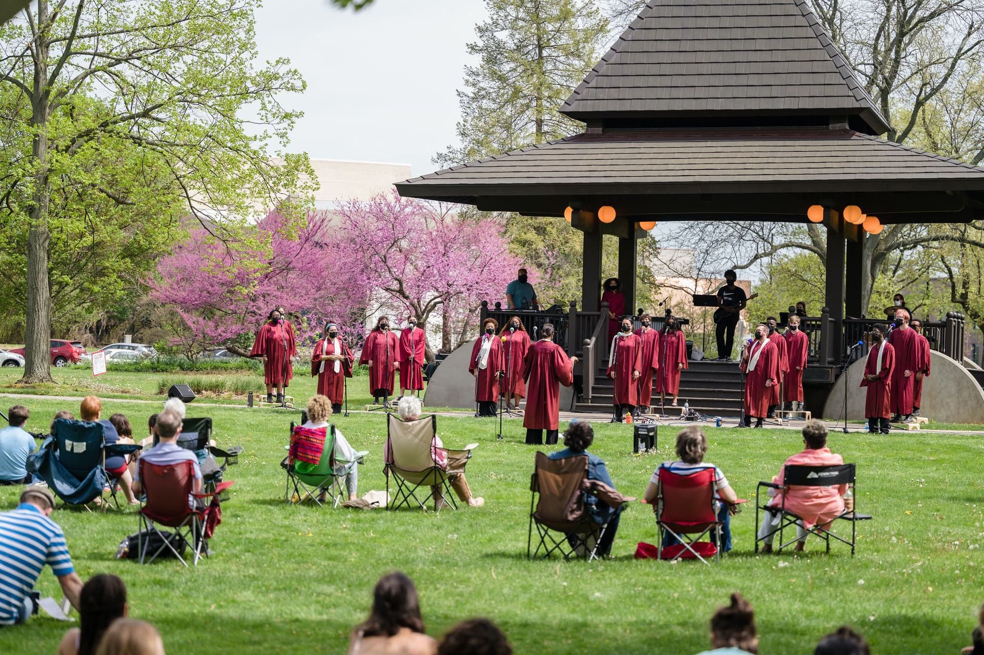 A gospel choir gives an outside concert in a park.