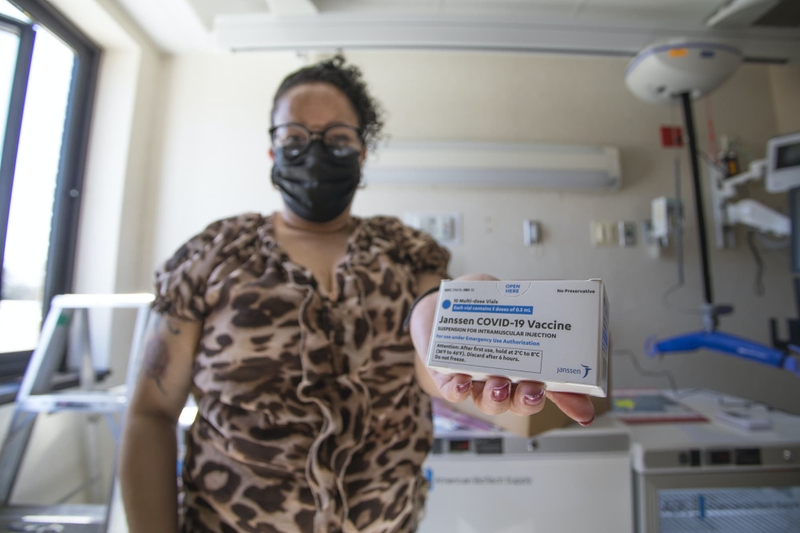 A woman holds a vaccination kit.