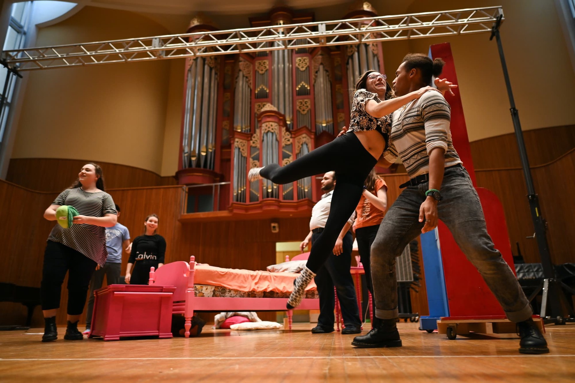 In a play rehearsal a student jumps in another student's arms.
