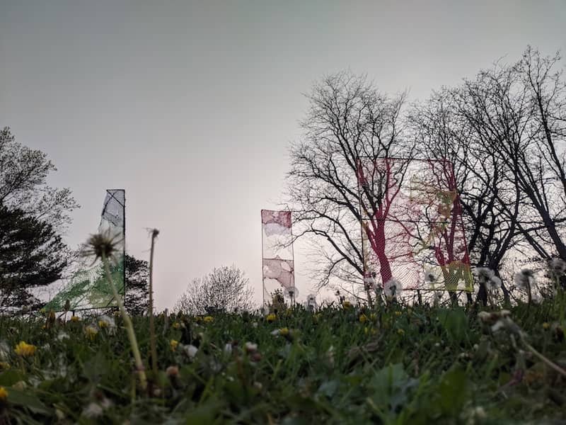 Three torn nets attached to pipes stand in an open field