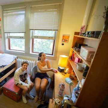 Two girls in a dorm room with streamed lights