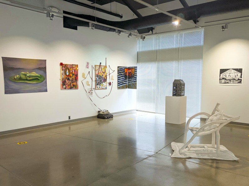 An art exhibition with sculptures, paintings, and drawings.