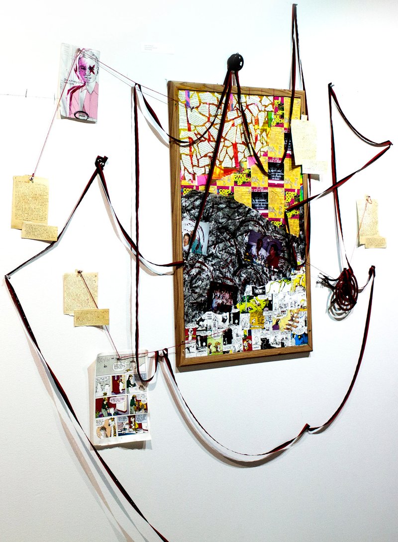 A cork board with designs is draped with typewriter tape.