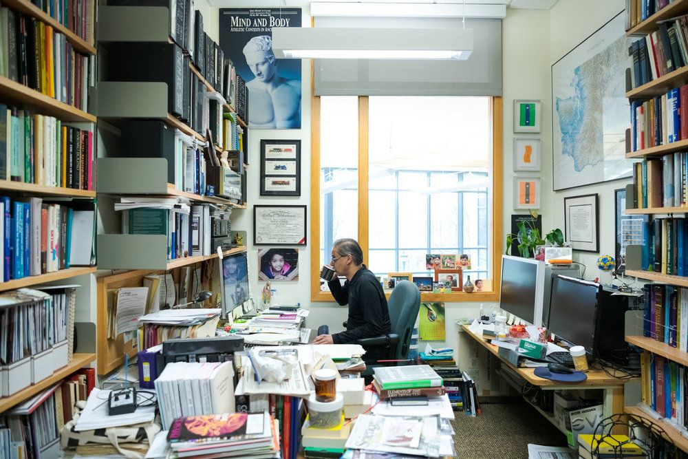 Professor in his office, drinking coffee.