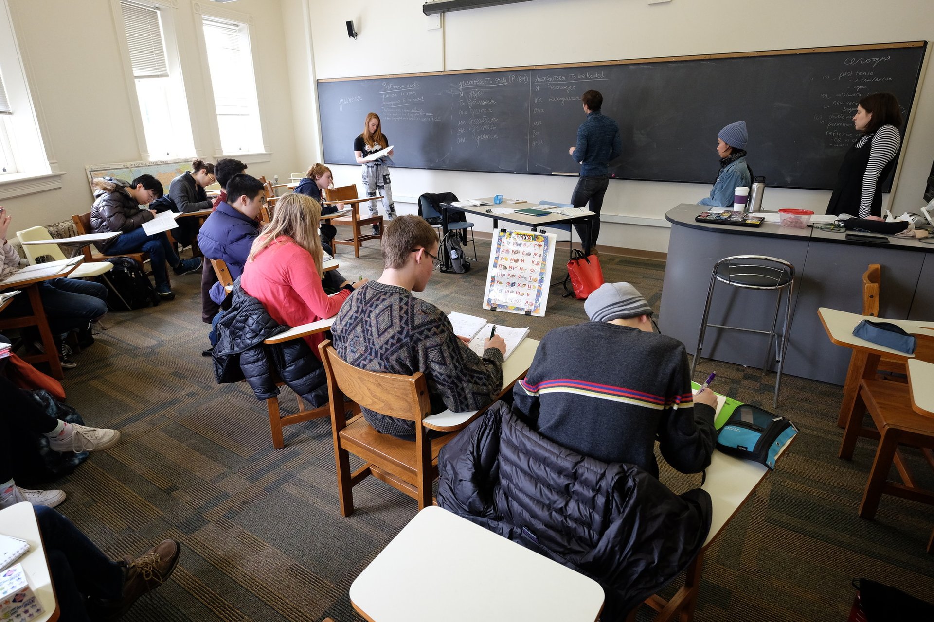 Students look at Russian words on a blackboard.