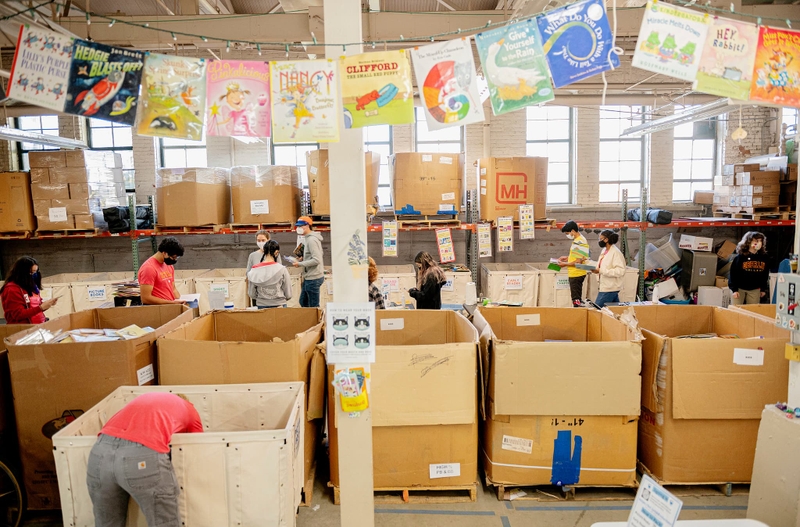 Students sort books in a large warehouse