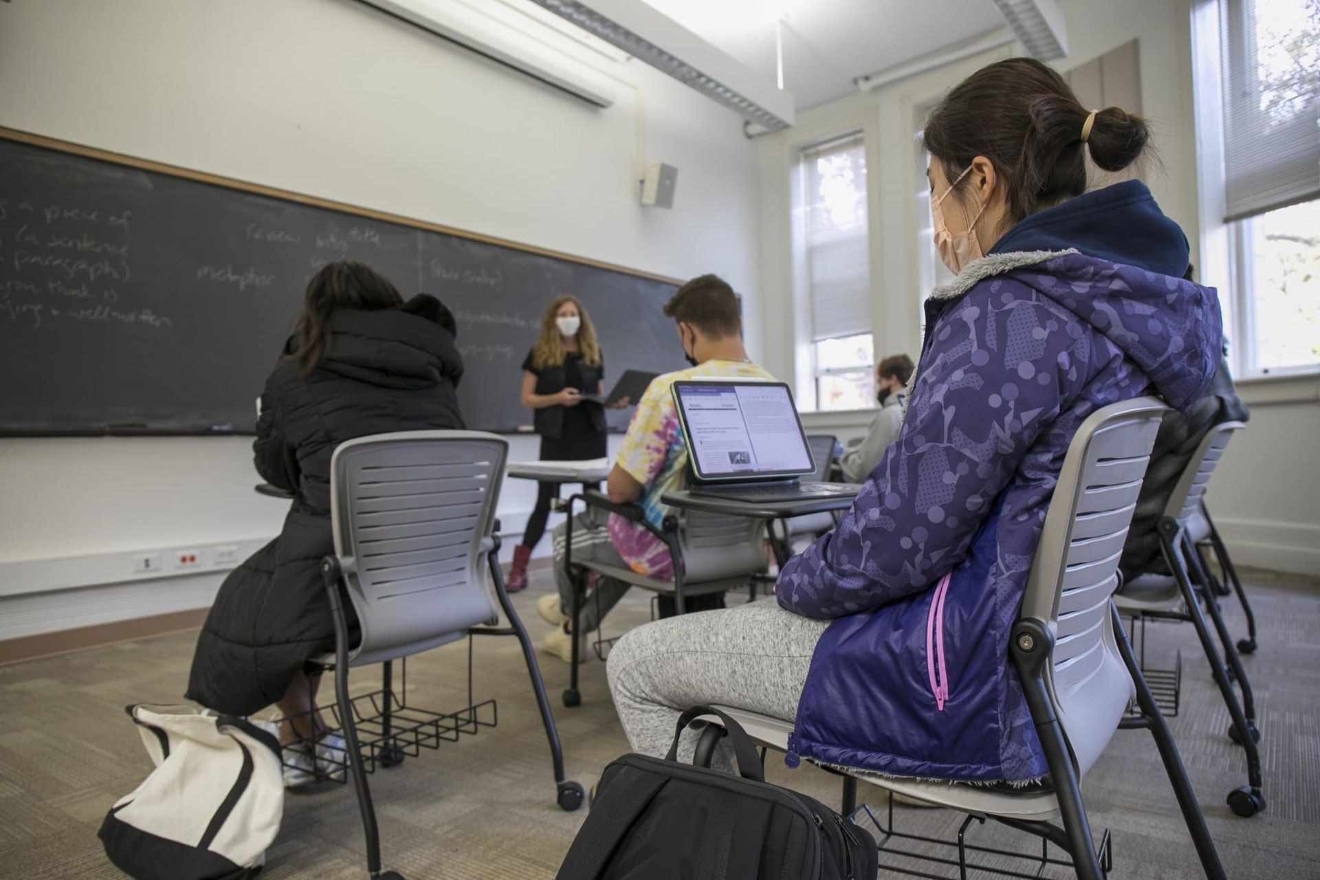 A girl looks at an instructor in a classroom.
