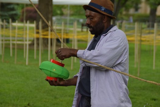 A man holds a lantern with a candle in it.