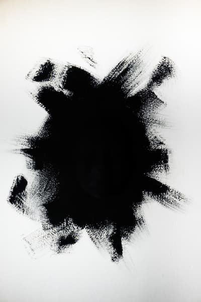 A large dark form in the center of a canvas