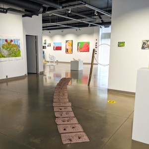 An art exhibition with sculptures, paintings, and drawings.