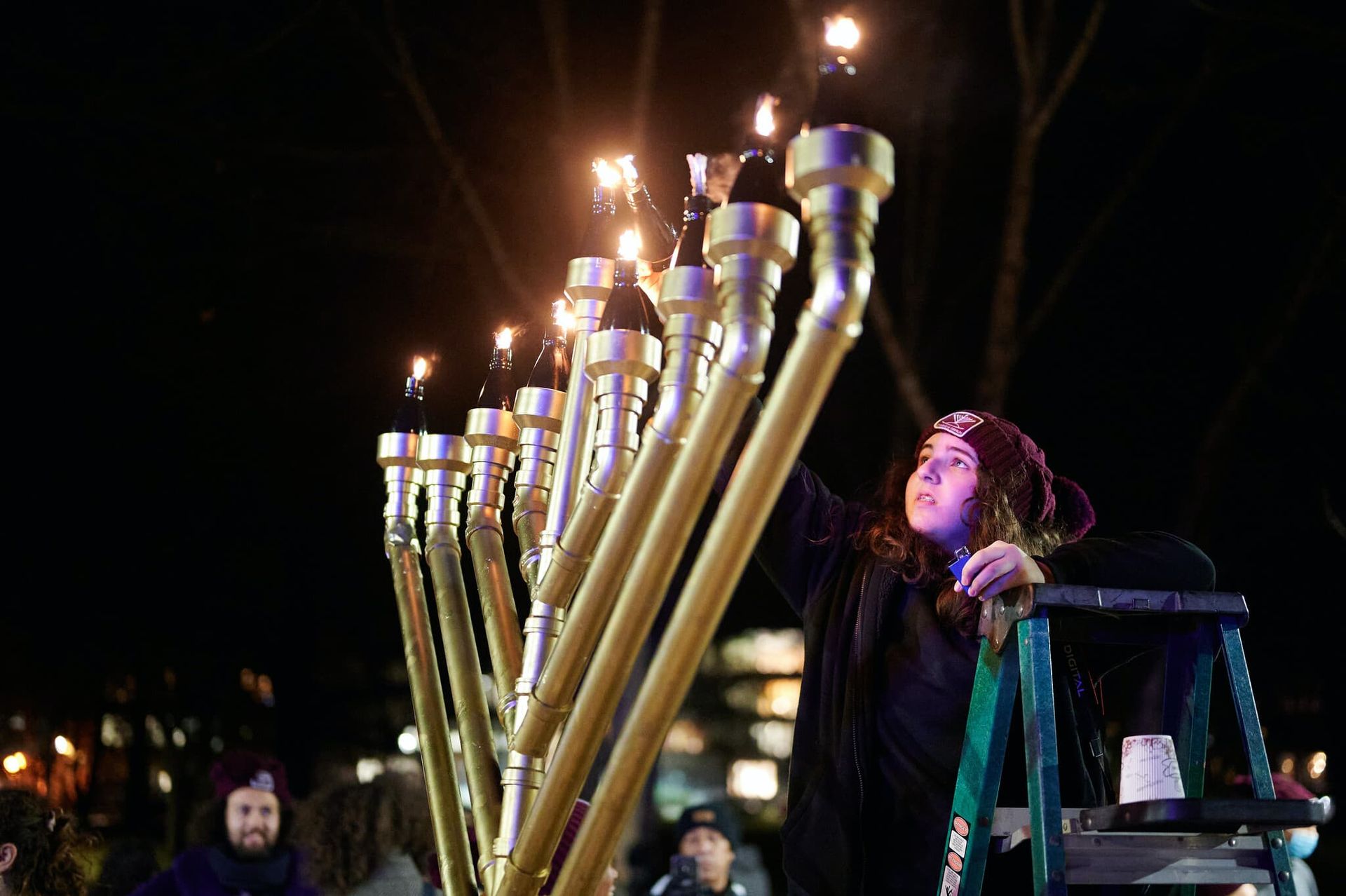 A girl lights a large menorah