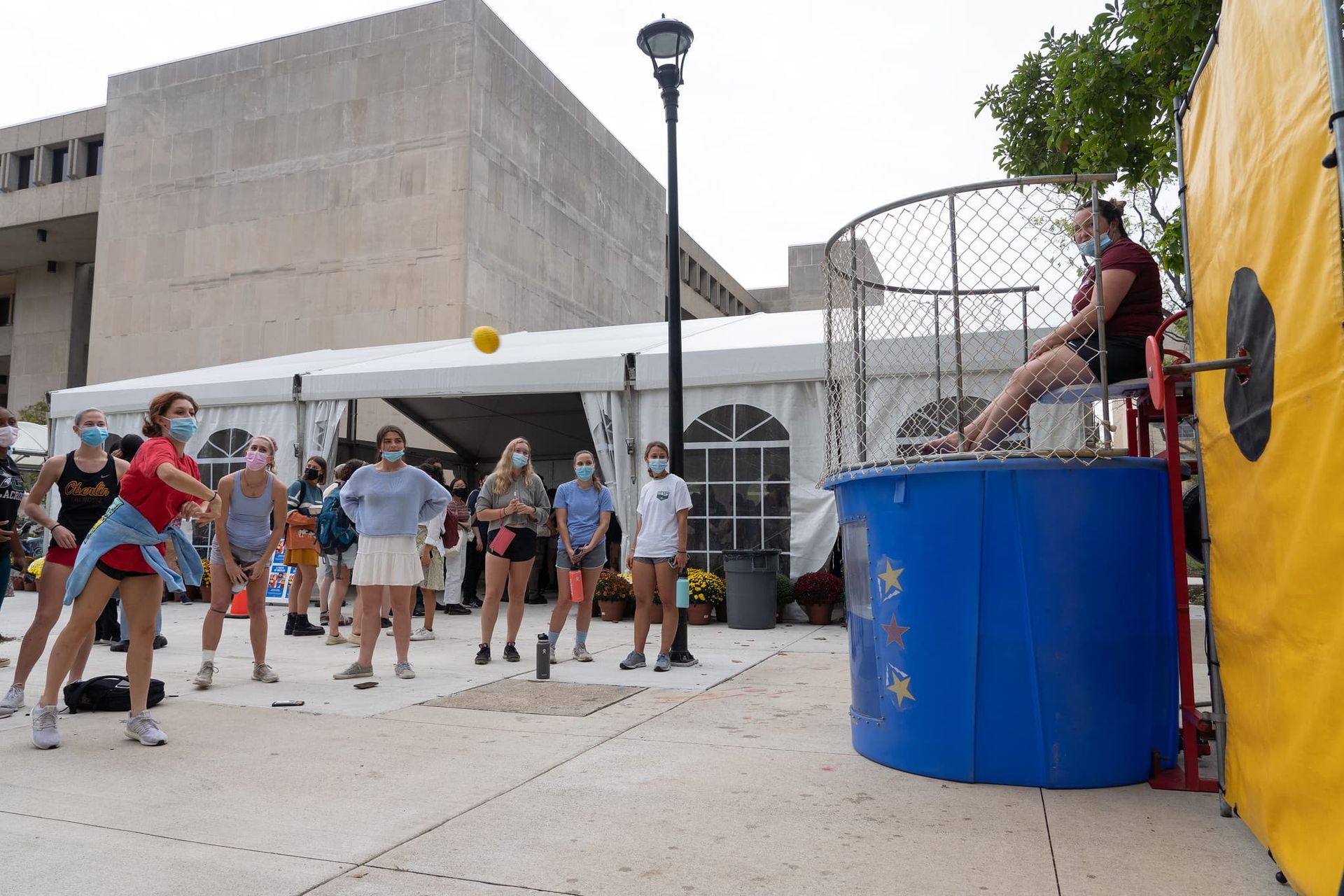 A girl throws a ball at a target.