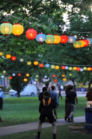 People walk under hanging lanterns