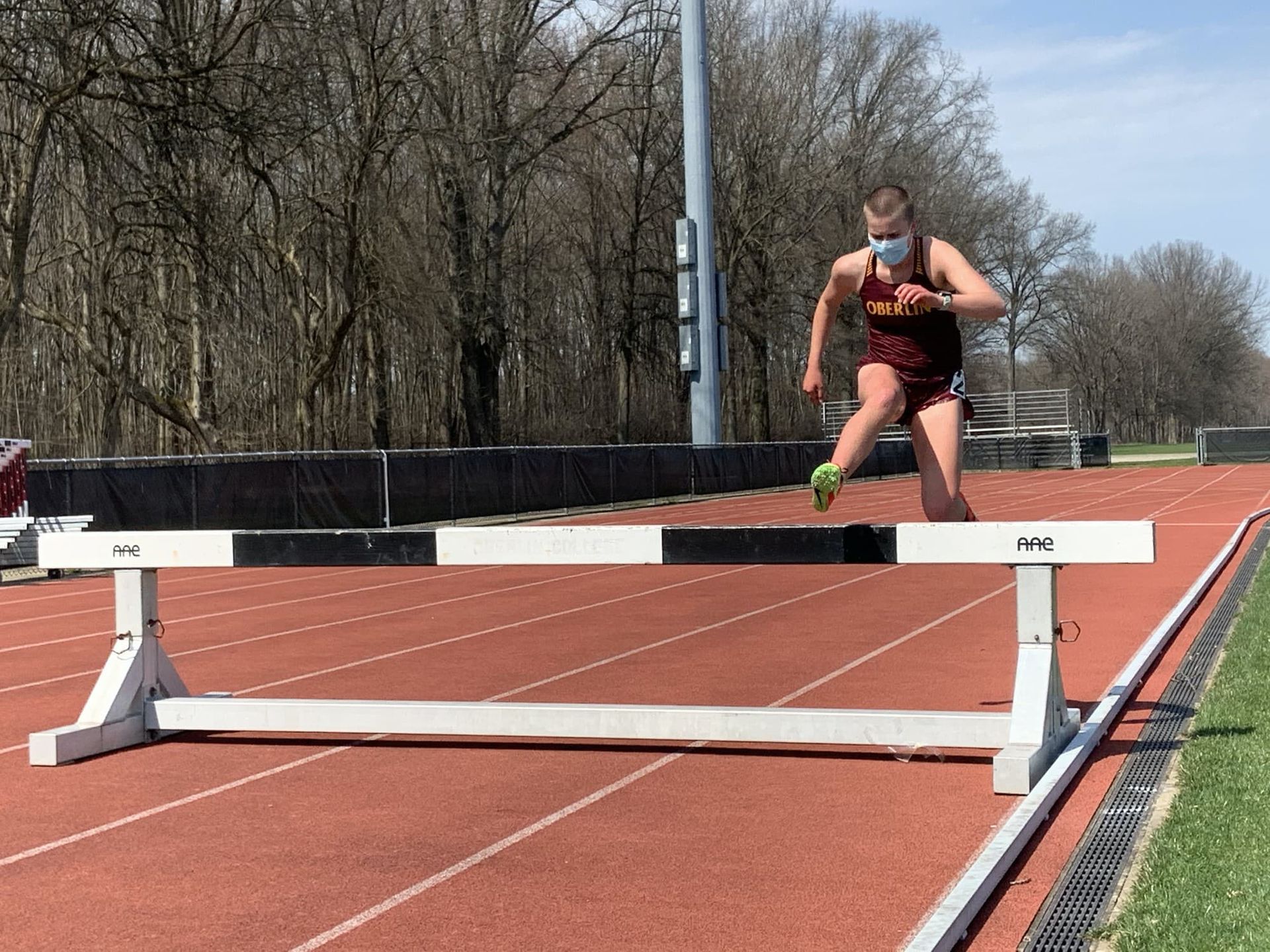 A runner jumps a hurdle
